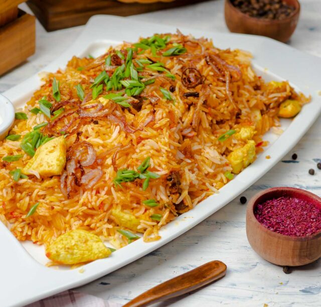 chicken-breast-tomato-sauce-rice-risotto-plov-with-herbs-yogurt-sumakh-white-plate